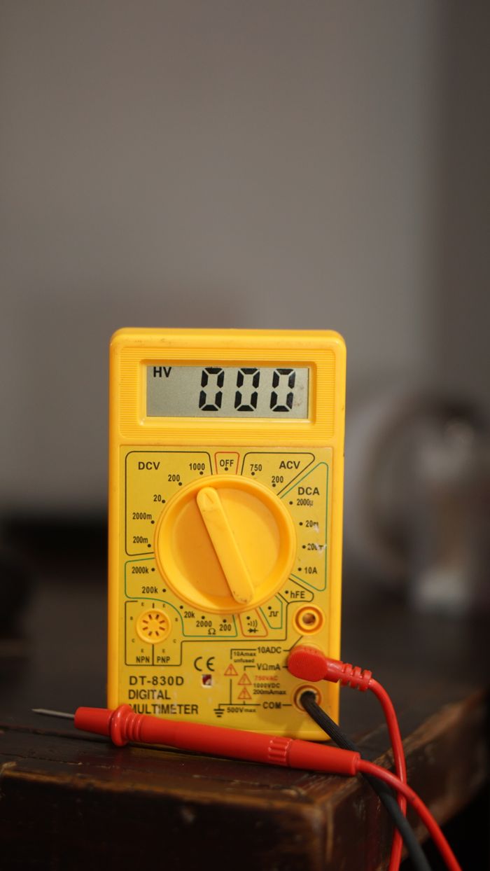 Close-up of a yellow digital multimeter with test probes, showing 0.00. Ideal for electronics and engineering visuals.